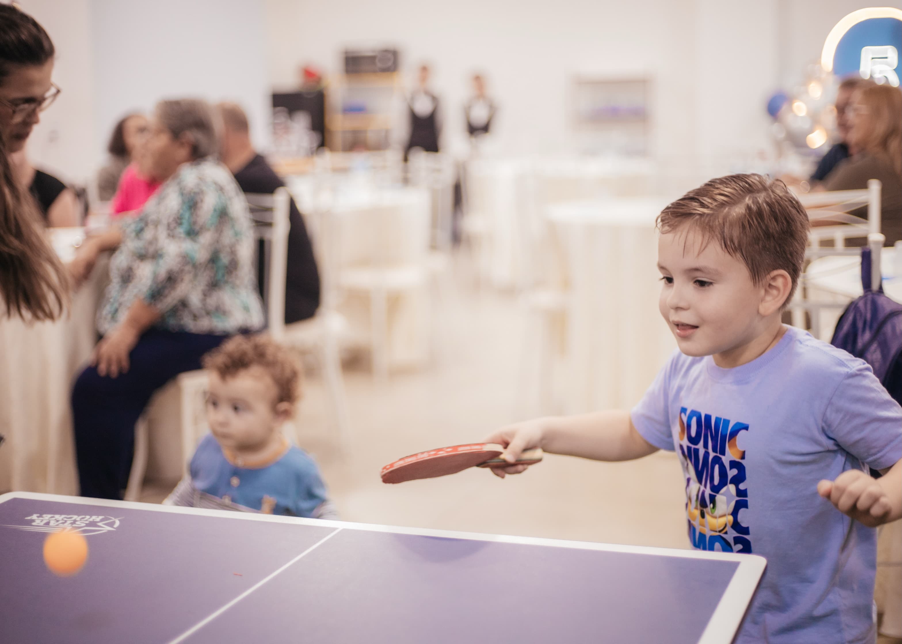 Criança jogando pingue-pongue em uma festa